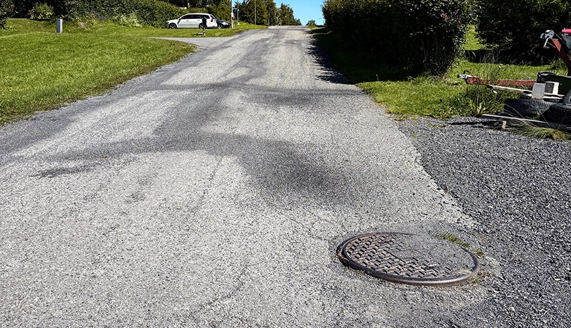 Närbild på spricka i asfaltsväg.