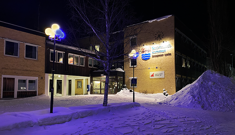 Kommunhuset med belysning i gult och blått.