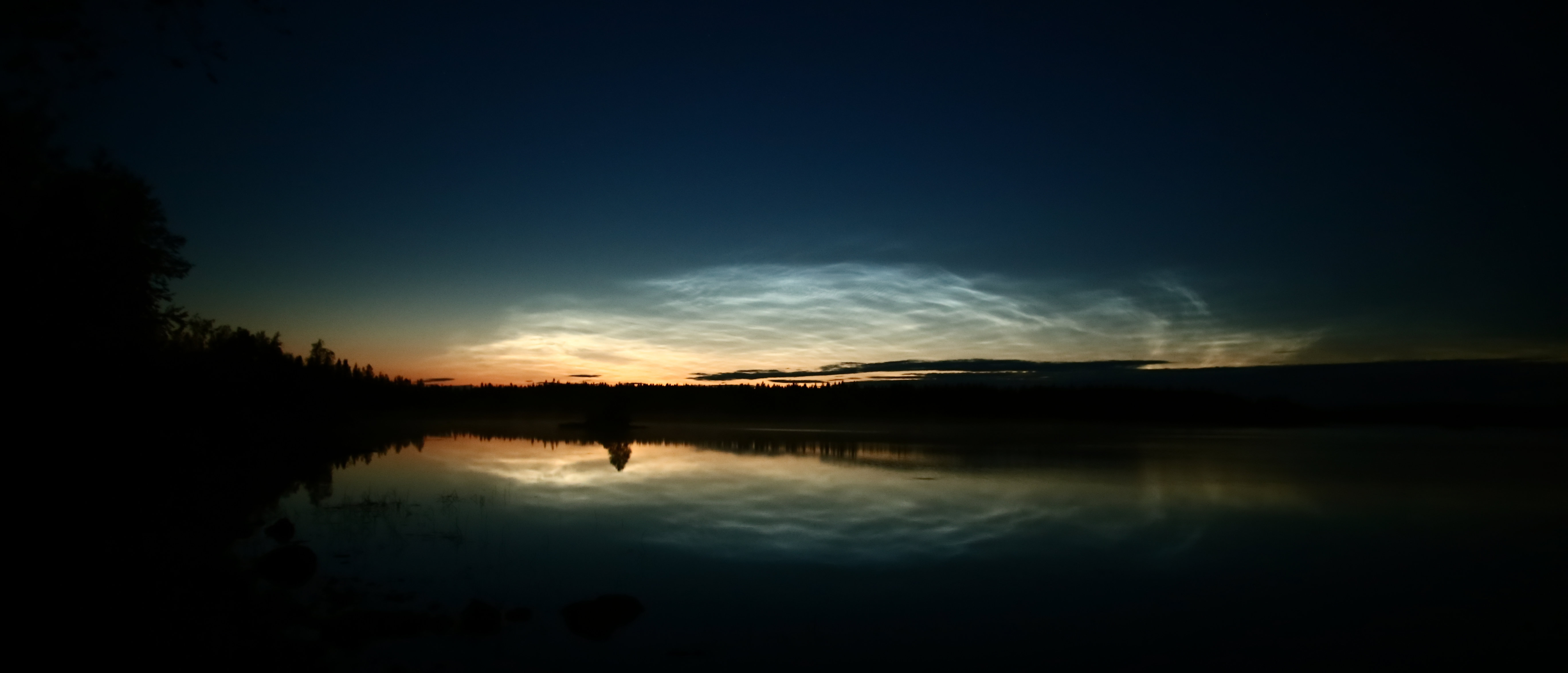 Rastplats vid Malgomaj 20190815, Vid kvällsskymningen belyser solen höga moln över sjön Malgomaj.