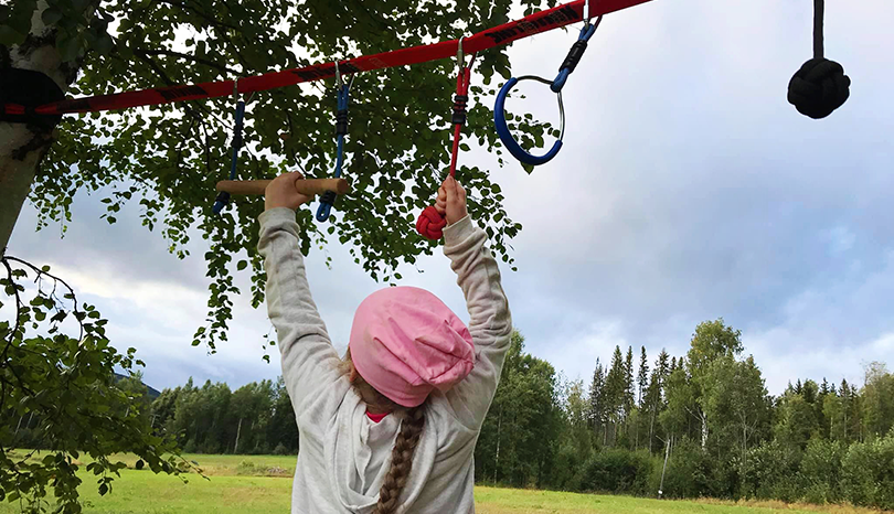 Flicka gör hinderbana i skog