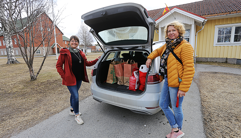 Två kvinnor står vid öppen bagagelucka