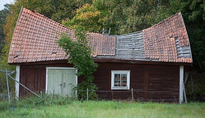 Rött hus med trasigt tak.