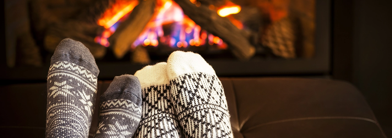 Fötter framför brasa.