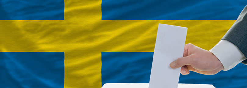 Man röstar med flagga i bakgrunden