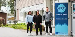 Tre personer står utomhus.