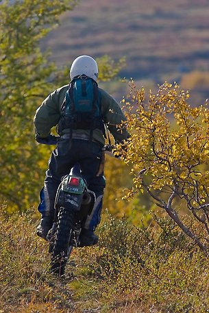 Man på motorcykel i fjällen.