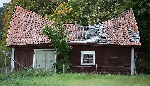 Rött hus med trasigt tak.